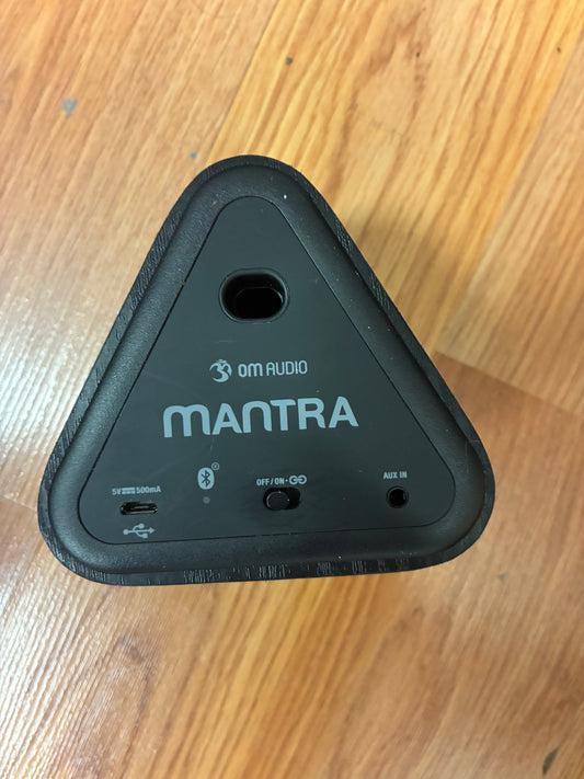 Black electronic device with 'Mantra' branding on a wooden surface